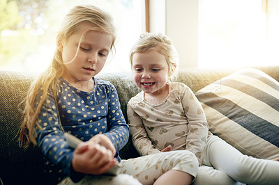 Buy stock photo Tablet, relax and sisters on sofa in home for playing educational game on app for learning. Digital technology, bonding and girl kids with online entertainment together in living room at house.
