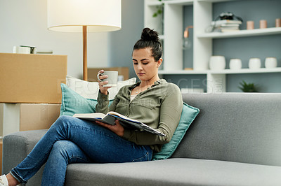 Buy stock photo Homeowner, reading book and woman on couch, relax and boxes with real estate, break and learning. Apartment, new property and person on sofa, coffee and novel with hobby, relocation and literature