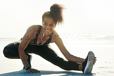 Buy stock photo Happy woman, fitness and stretching leg with earphones on beach for workout preparation in nature. Active, female person or runner with smile for warm up, flexibility or start exercise on ocean coast