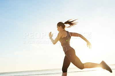 Buy stock photo Woman, running and workout at beach with earphones, training or listen to music with mock up space at sunrise. Girl, person and exercise with streaming, subscription and fitness with speed in Spain