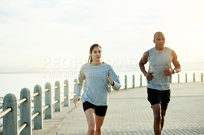 Buy stock photo Promenade, couple and fitness with running for sports, cardiovascular health and wellness with exercise. Outdoor, man and woman with training for marathon challenge, endurance and energy by beach