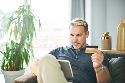 Buy stock photo Credit card, tablet and man with online shopping in home for ecommerce, payment or sale on sofa. Customer, website and person with banking app in living room for transaction, subscription or order
