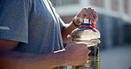 Man, hands and fitness with water bottle in city for outdoor workout break, hydration or recovery. Active, male person or rest with mineral liquid for sustainability, vitamins or nutrition in town