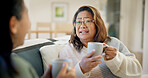 Sofa, coffee and mom with adult daughter in home for conversation, friendly chat or discussion. Mother, woman and communication with visit, drink or mug for bonding, rumor or gossip together in house