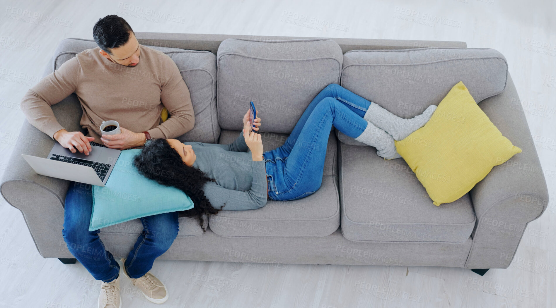Buy stock photo Above, relax and couple on sofa with phone, laptop and talking for bonding on weekend break. Home, marriage and man with woman on cellphone, website or computer for internet, watching videos and rest