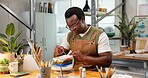 Potter, man and painting in studio for ceramic decoration, custom design or handmade creation. Pottery, black person or unique art on sculpture for small business order, merchandise or color pattern