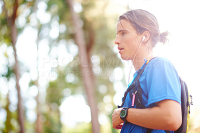 Buy stock photo Fitness, man and resting in forest with earphones for music playlist, exercise break and cardio challenge. Space, runner and tired in nature with audio album, marathon endurance and wellness journey