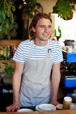Buy stock photo Barista, happy and man in coffee shop at counter for serving, customer service and friendly welcome. Restaurant, hospitality industry and confident person, server and waiter in cafeteria for startup