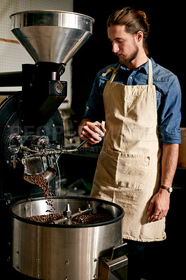 Buy stock photo Barista, man and beans in coffee roaster machine for manufacturing, production process or preparation. Roasting, worker and caffeine in factory for quality control, blend and small business in cafe