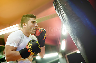 Buy stock photo Boxing bag, exercise and man in gym for training, challenge or cardio activity for practice. Fitness, intense power and male athlete with punching equipment for performance or workout in sport center
