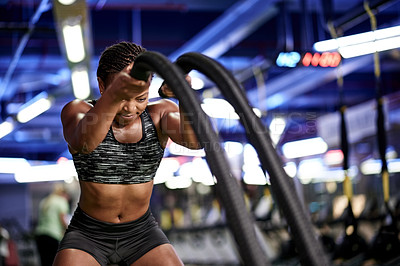 Buy stock photo Battle ropes, exercise and black woman in gym for fitness, bodybuilder workout and training. Sports, intense and person with muscle strength, power and equipment for wellness, health and challenge
