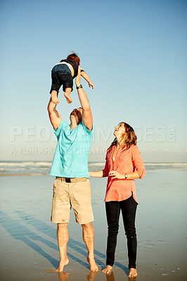 Buy stock photo Beach, happy and parents with child in air for playing, bonding and relax outdoor on holiday. Family, travel and playful dad, mom and kid by ocean for adventure, vacation and weekend in nature