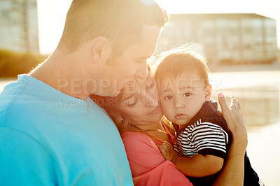 Buy stock photo Hug, parents and child at beach for holiday, summer trip and bonding together. Father, mother and carry toddler at seashore for family vacation, flare or travel for tourism with portrait of kid