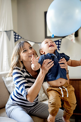 Buy stock photo Mother, toddler and balloons with laughing in living room for party with celebration for milestone. Woman, happy child and play with decorations for birthday event with love and fun in family home