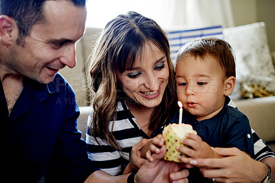 Buy stock photo Parents, kid and cupcake for birthday in house for milestone with blowing candle for celebration. Dessert, sweets and mother with boy toddler, father and cake at party or event in family home
