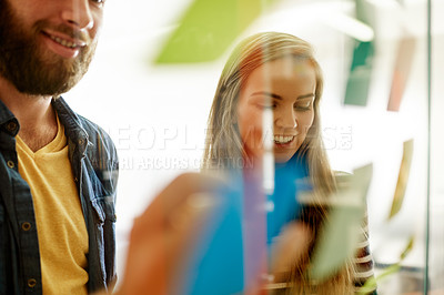 Buy stock photo Brainstorming, writing and people at glass wall with sticky note, strategy or ideas in startup. Smile, collaboration or team in office with problem solving, planning or solution in creative business.