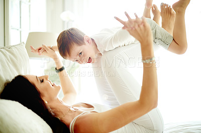 Buy stock photo Flying game, mother and son on bed with smile, love and connection for bonding together. Portrait, parent or child laughing in home with support, relationship building or playing airplane on weekend.