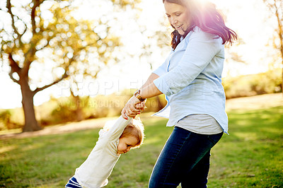 Buy stock photo Mother, spin child and play at park with smile, bonding and flare with love, fun and summer in nature. People, mom and daughter with games for toddler, swing or holding hands with care in Portugal