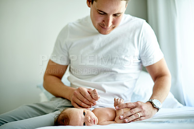 Buy stock photo Dad, baby and care on bed in home for love, smile or bonding with play in morning. People, father and newborn with holding hands, comfort or affection with infant child in nursery at family house