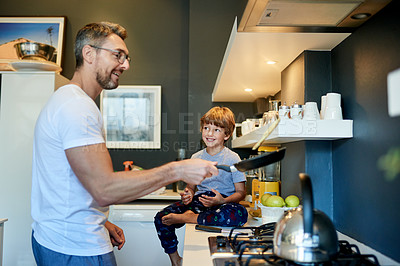 Buy stock photo Cooking, counter and father with child in kitchen with conversation, bonding and morning routine. Smile, connection and dad with boy kid for preparing breakfast together on weekend in apartment.