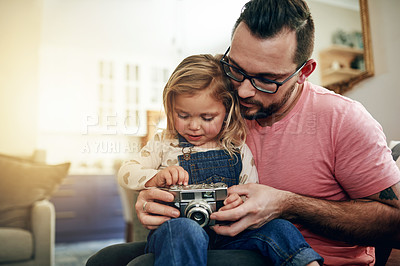 Buy stock photo Camera, pictures and man with child, lounge and bonding with daughter in house, vintage and weekend. Family, home and photography with retro tech, kid and hobby with dad, growth or skill development