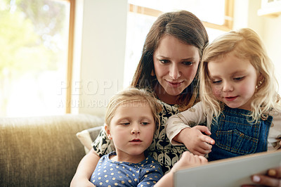 Buy stock photo Tablet, relax and mother with girl kids on sofa in living room of home for development. App, elearning or reading with single parent woman and daughter children in apartment together for growth