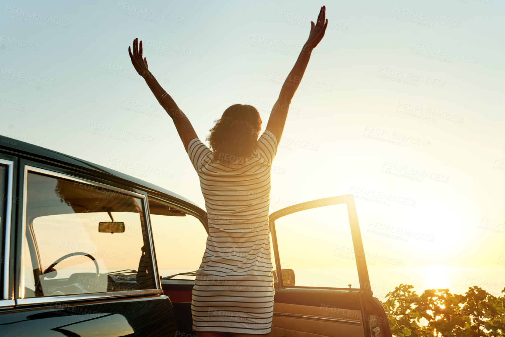 Buy stock photo Shot of a happy young woman enjoying a road trip