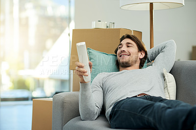 Buy stock photo Happy, TV and man on sofa with remote for watching movies, channel and streaming in new home. Moving, boxes and person on couch to rest for online subscription, entertainment or series in living room