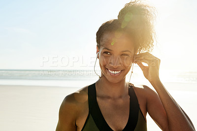 Buy stock photo Woman, earphones and music at beach for fitness, sky and space with flare for training routine in nature. Person, outdoor and listen with audio subscription, smile and reflection by ocean in Brazil