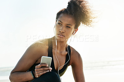 Buy stock photo Woman, smartphone and fitness at beach with earphones, reflection and music for exercise by sea. Girl, thinking and runner on break with space, sky or mobile app for subscription by ocean in Ecuador