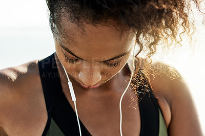 Buy stock photo Earphones, fatigue and fitness with woman on beach for recovery or rest from cardio training. Exercise, exhaustion and music with tired African athlete outdoor for health, relax or workout break