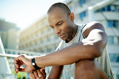 Buy stock photo Black man, smart watch and exercise on bridge in city, break or low angle for record, fitness and training. Person, runner and rest with clock, timer app or heart rate for cardio wellness in Nigeria