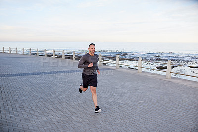 Buy stock photo Mature man, running and workout on beach promenade, sports fitness and activity on mockup space. Male person, physical challenge and training for marathon, outdoor jog and cardiovascular exercise
