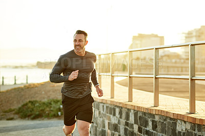 Buy stock photo Mature man, running and fitness on ocean promenade, sports workout and activity for mobility health. Male person, physical challenge and training for marathon, outdoor and cardiovascular exercise