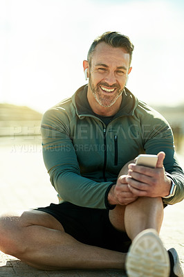 Buy stock photo Man, portrait and outdoor with phone for fitness, music and wellness tracking app for care. Mature athlete, mobile and smile in Portugal for streaming service, favorite playlist and warm up tutorial