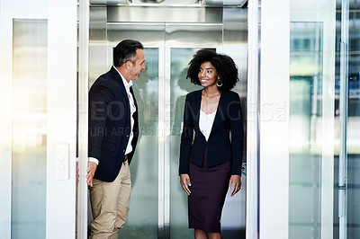 Buy stock photo Business, people and leaving elevator in office for work arrival, enter building and employee respect. Woman, man and holding lift door with courtesy for exit, company floor or walking to appointment