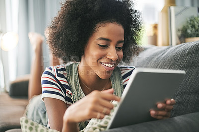 Buy stock photo Black woman, tablet and scroll on sofa, relax and happy with streaming, movies or ebook in home. African girl, smile and tech on couch, laying and video on app with film subscription at apartment