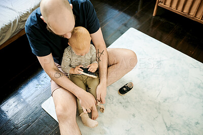 Buy stock photo Helping, shoes and father with baby in living room for ready, morning routine and clothes. Bonding, support and care with man and young child in family home for happy, change and learning from above