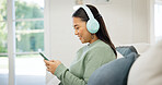 Headphones, relax or asian woman on sofa in home for audio streaming or entertainment app. Happy, female person or listening with smile, phone or sound for network connection or subscription in house