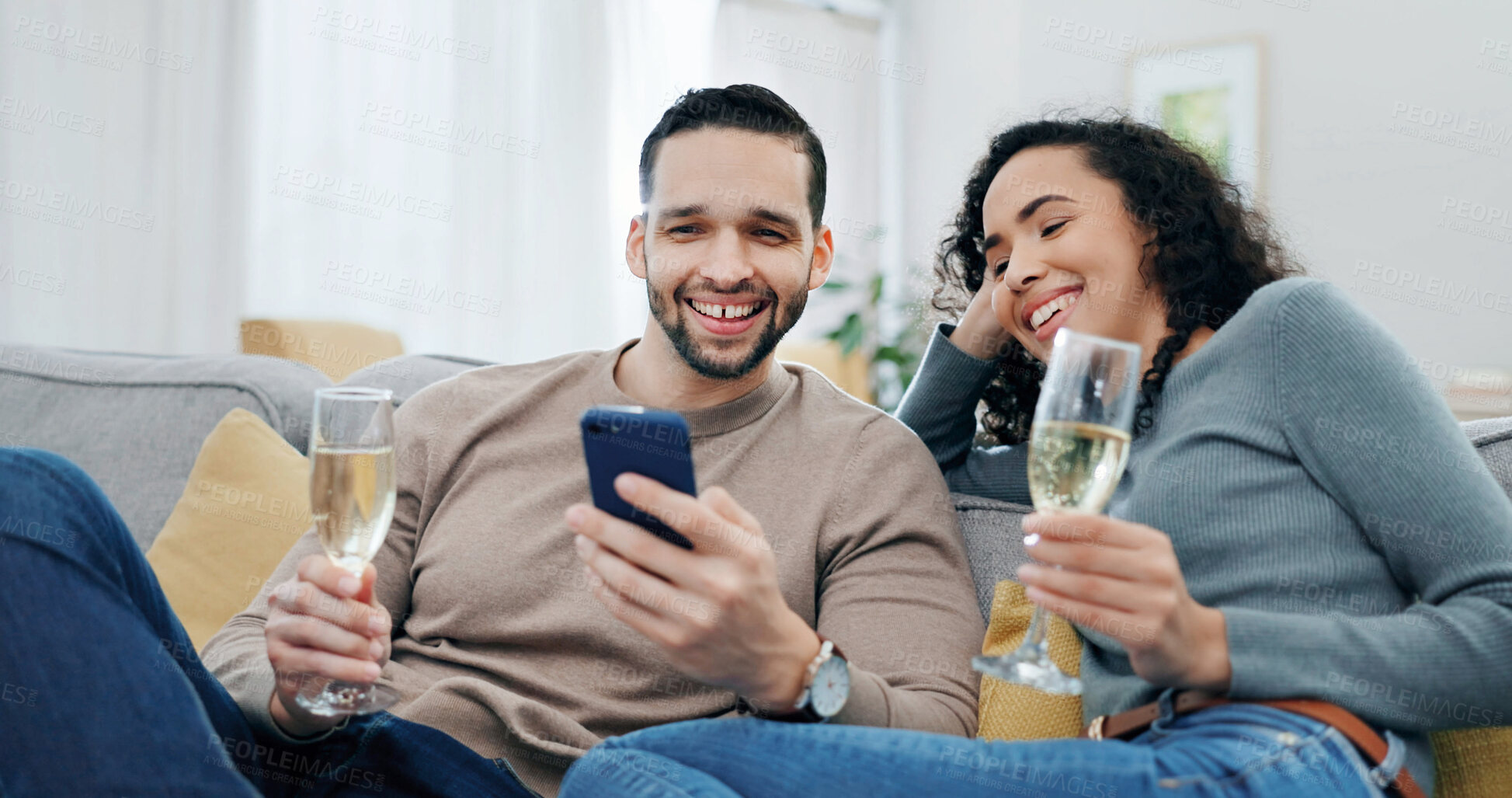 Buy stock photo Smile, couple and alcohol at house with phone, social media and browsing website on romantic date. Happy, people and champagne in home with mobile, internet search and celebration for anniversary