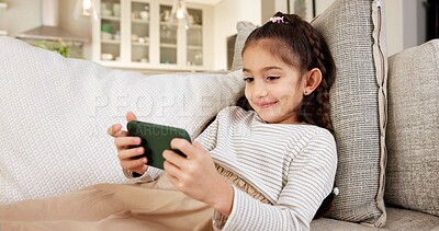 Buy stock photo Happy, girl or child with phone on sofa for online streaming, gaming or entertainment in home. Kid, user or interaction with smile, technology or app for mobile network service or connection in house