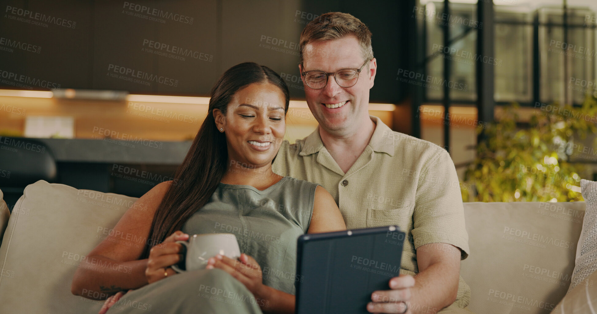 Buy stock photo Relax, happy and tablet with interracial couple on sofa for streaming service, bonding and love. Film subscription, connection and smile with man and woman in living room in home for media app