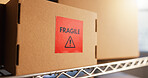 Warehouse, empty and box with fragile label for shipping, supply chain and inventory with warning. Cardboard, workshop and caution on package, parcel and stock for distribution, shipment or logistics