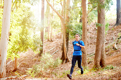 Buy stock photo Fitness, man and running in forest with exercise for marathon competition, endurance challenge and cardio. Trail runner, athlete and backpack in woods for training performance, wellness and workout