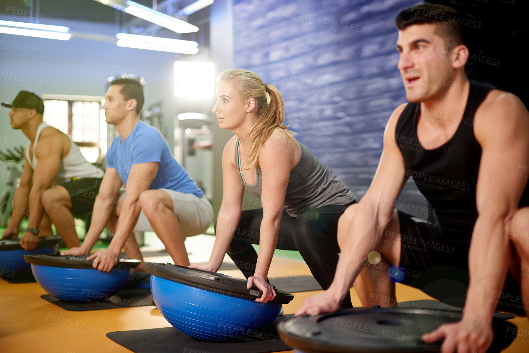 Buy stock photo Medicine ball, fitness and athletes with personal trainer in gym for core strength workout together. Squat, equipment and people with health coach for balance training with wellness in sports center.