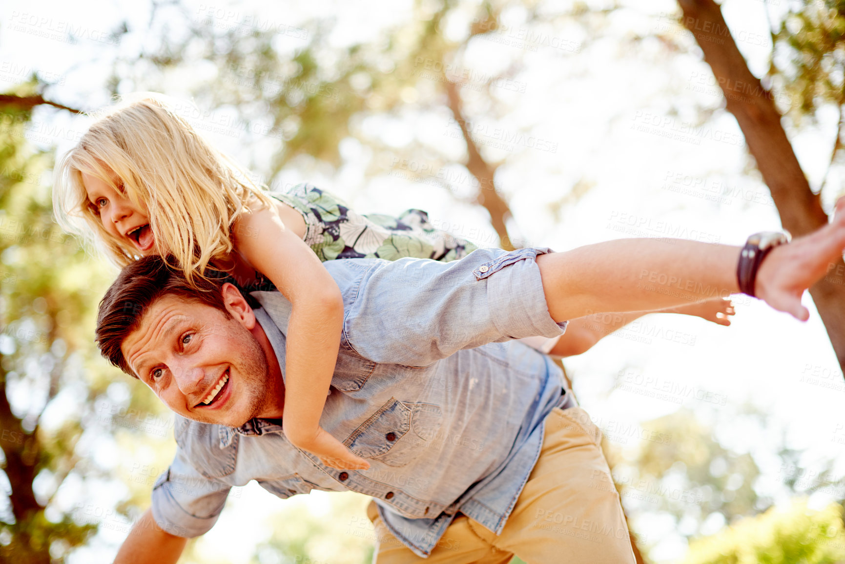 Buy stock photo Happy, father and girl with piggyback at park for airplane game, imagination and fantasy fun. Low angle, dad and carry child on back in nature for playing together, freedom and support with adventure