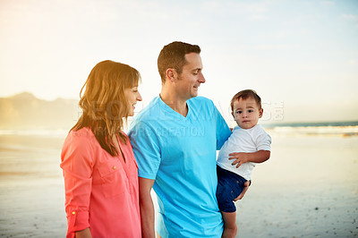 Buy stock photo Parents, baby and walk at beach on vacation with smile, care and bonding with love in summer. People, mom and dad with toddler child, space and happy by ocean for family holiday in New Zealand