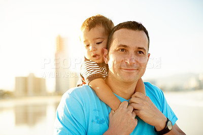 Buy stock photo Dad, toddler and piggyback at beach with smile, connection or love for father son bonding on holiday. Happy man, boy child with back hug outdoor, sunshine and adventure with travel view in Australia