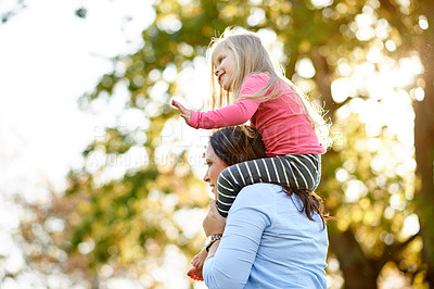 Buy stock photo Happy girl, lift and shoulder with mom in nature for bonding, weekend or outdoor adventure together. Child, kid or mother carrying daughter with smile for playful holiday, family time or walk in park