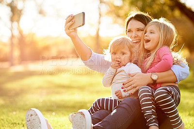 Buy stock photo Mom, selfie and girl kids at park with smile, hug and care for post on web, relax and bonding on grass. People, mother and daughter with photography, profile picture or happy on ground in Spain